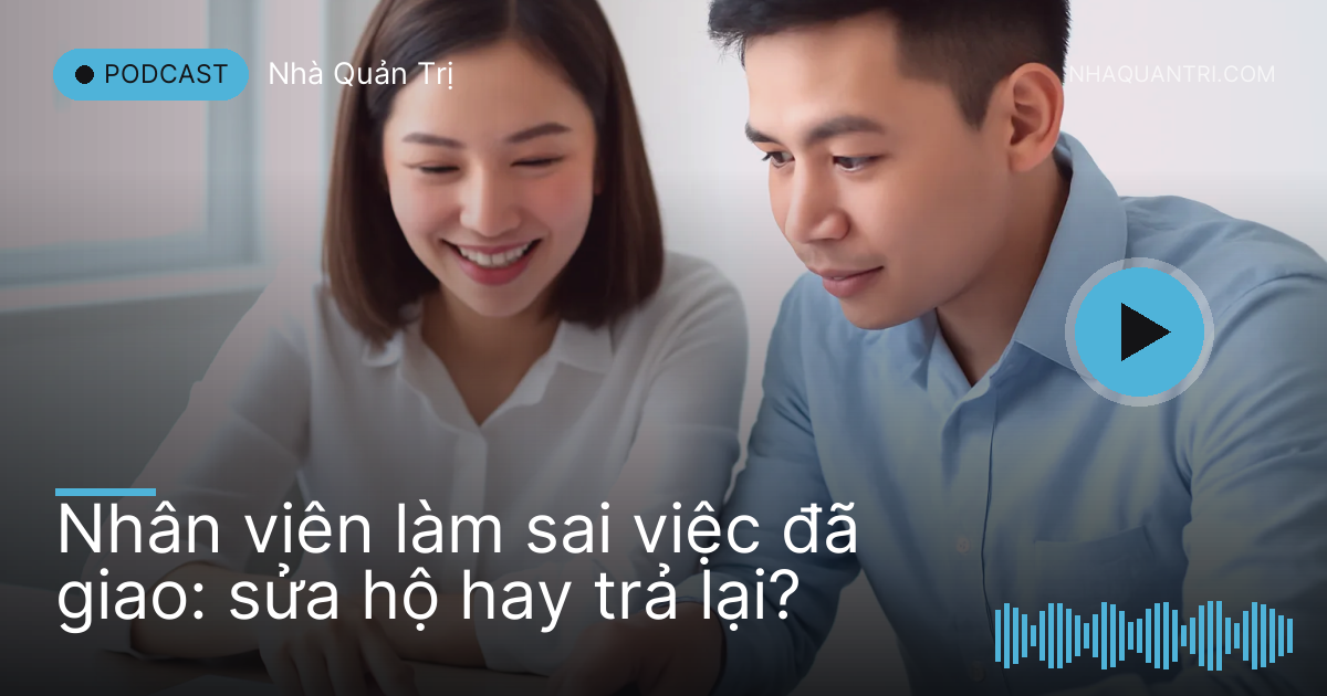 Hai người cúi xem tập giấy in mờ trên bàn trong phòng họp nhỏ sáng