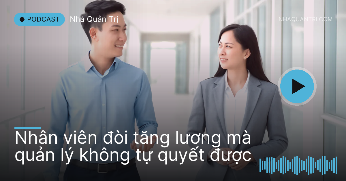 Anh nhân viên trẻ và chị quản lý vừa đi vừa trò chuyện trên hành lang toà nhà