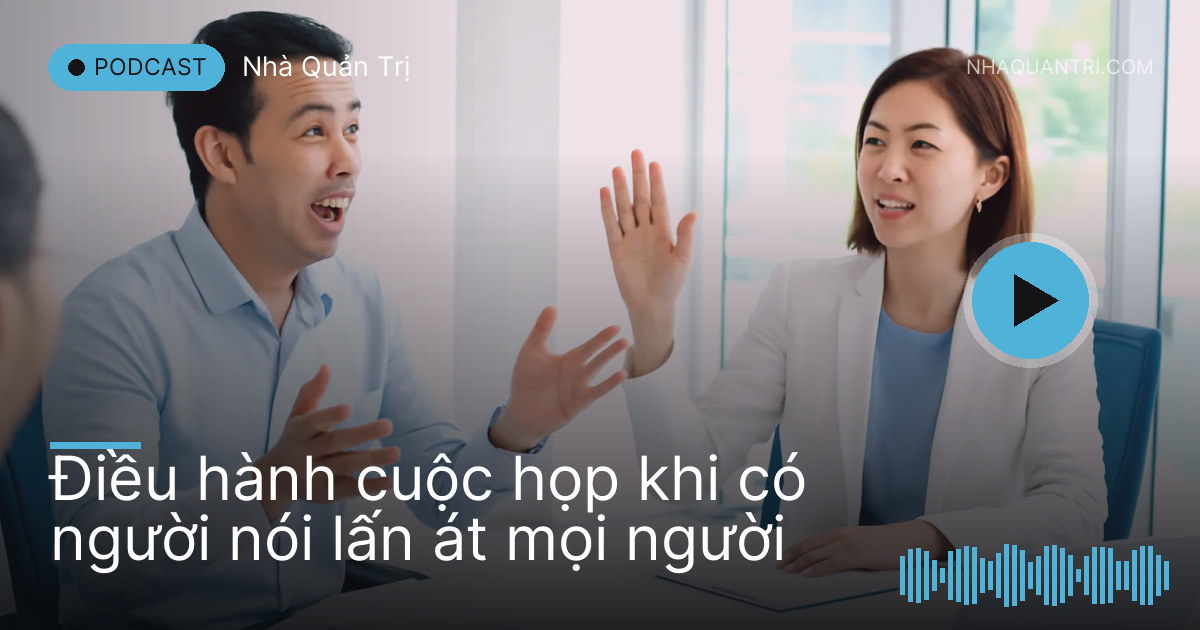 Phòng họp dài, một người đang nói, chị chủ trì giơ tay ra hiệu nhẹ nhàng