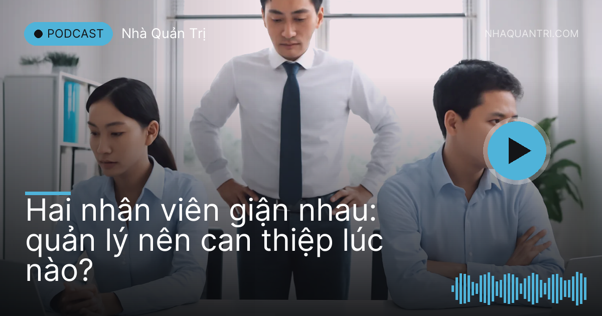 Hai nhân viên ngồi hai đầu bàn quay mặt đi, người quản lý đứng ở giữa