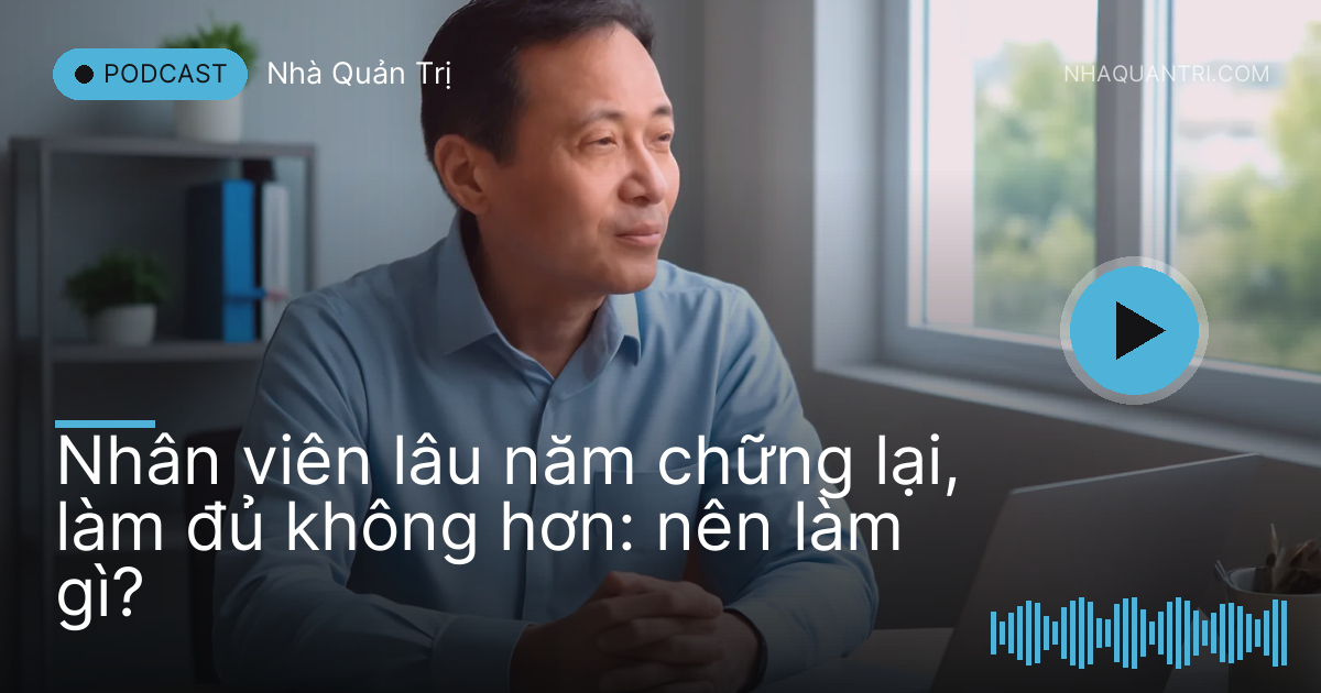 Người đàn ông trung niên ngồi bàn làm việc gọn gàng nhìn ra cửa sổ buổi chiều