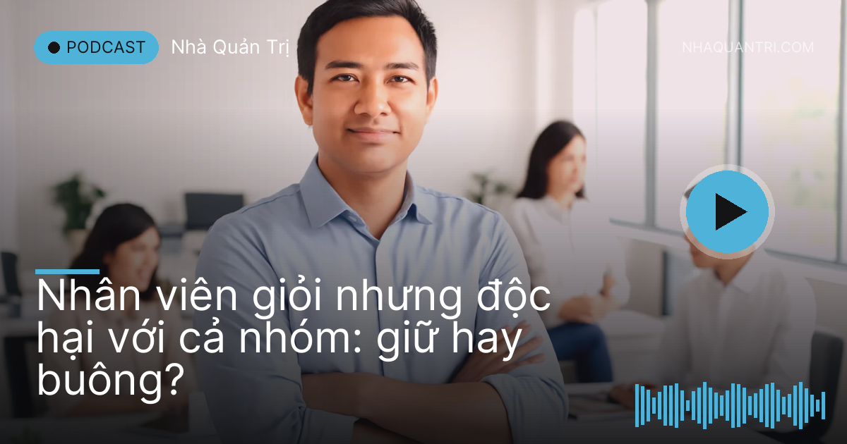 Một người đứng khoanh tay giữa phòng, đồng nghiệp xung quanh né ánh mắt