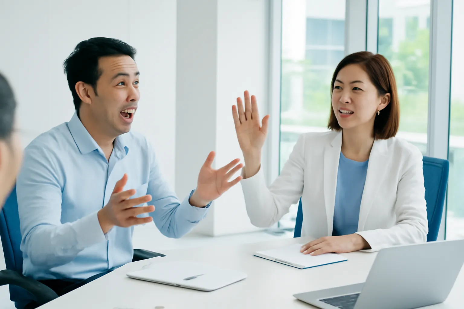 Phòng họp dài, một người đang nói, chị chủ trì giơ tay ra hiệu nhẹ nhàng